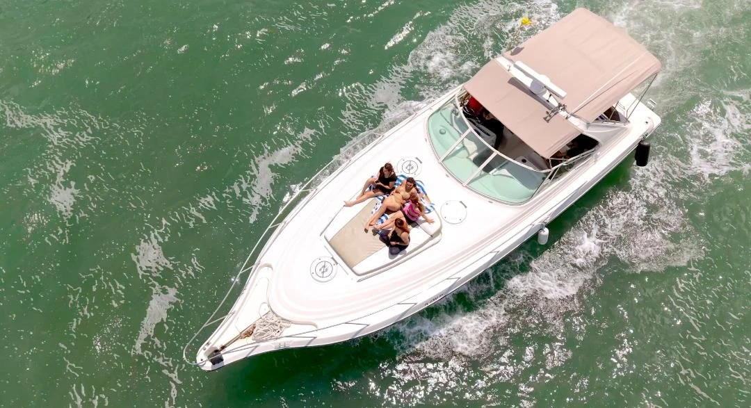 Aerial view of the yacht with guests on the bow